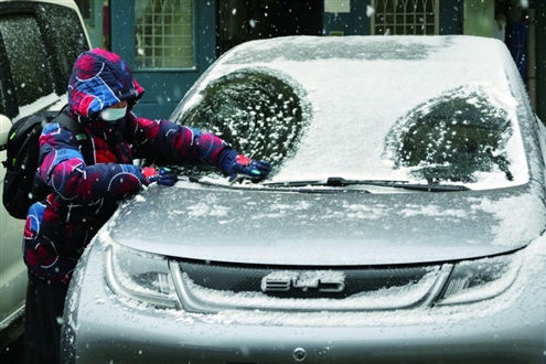 2日,一名小朋友在烟台街头玩雪